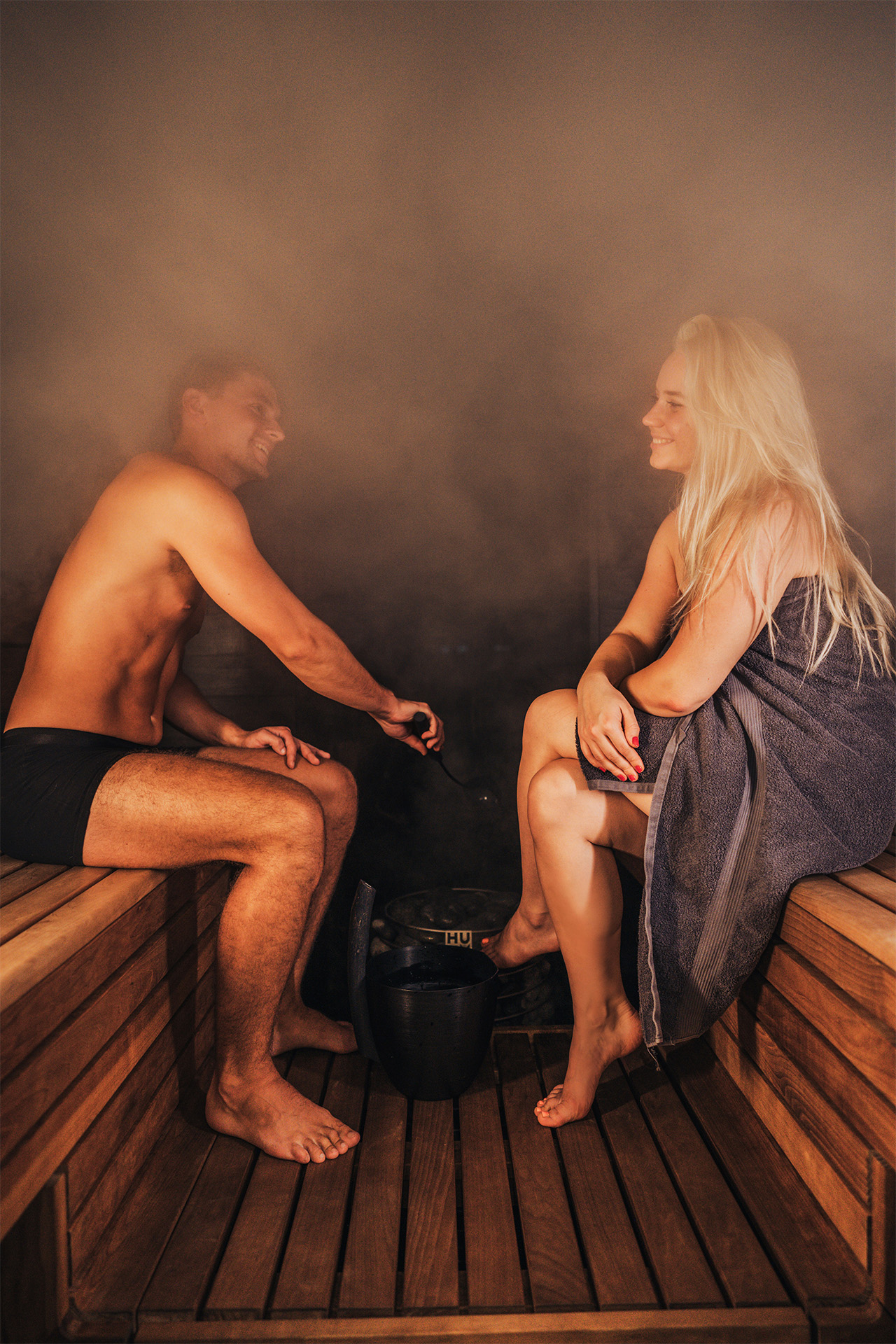 Two people relaxing in a timber sauna
